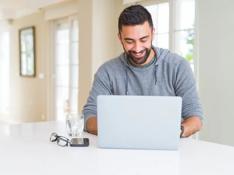 Image of a person smiling on the computer.