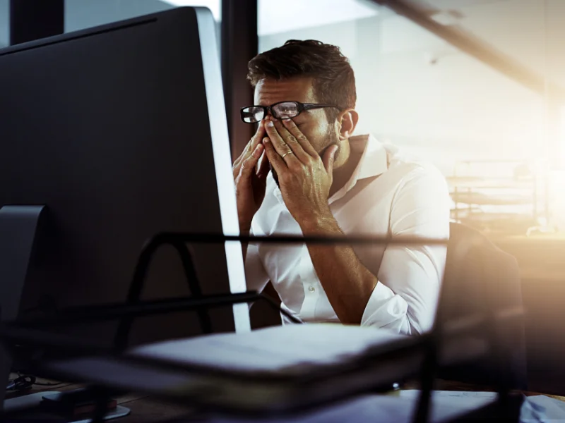 Image of a frustrated business owner on the computer over poor ad performance.