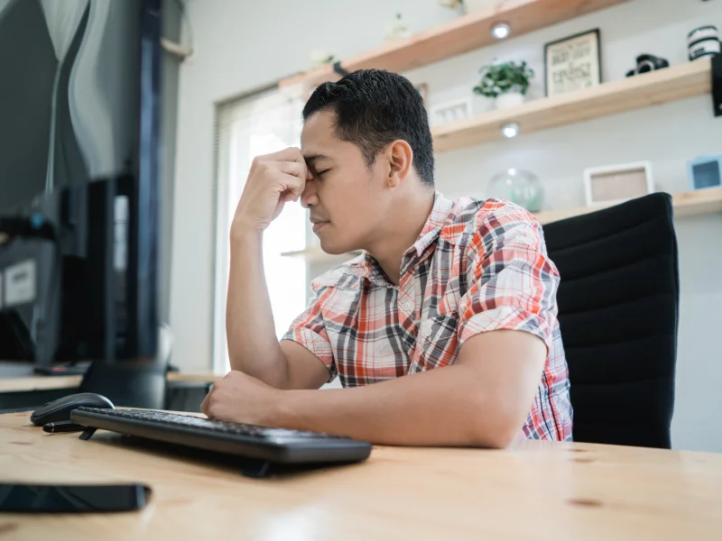 Image of an unhappy busines owner on the computer.